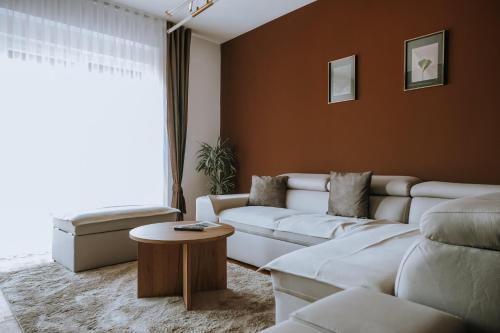 a living room with a white couch and a table at Lux Nest Apartment Prishtina in Pristina