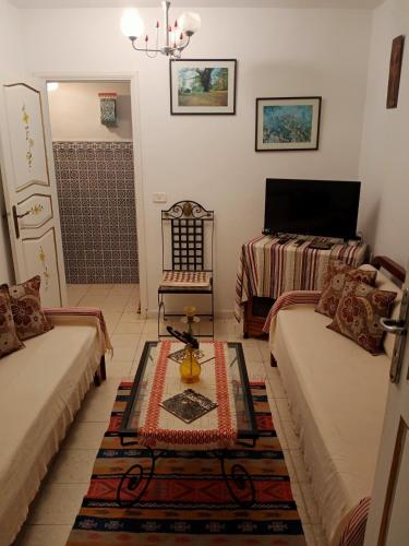 a living room with two couches and a shower at Paradis in Dar Salah Bey