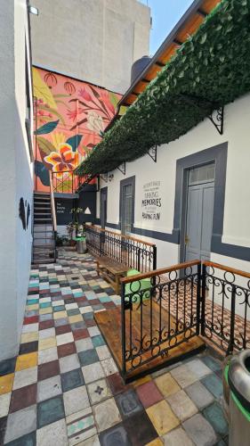 a mural on the side of a building with benches at Casa Columpio in Mexico City
