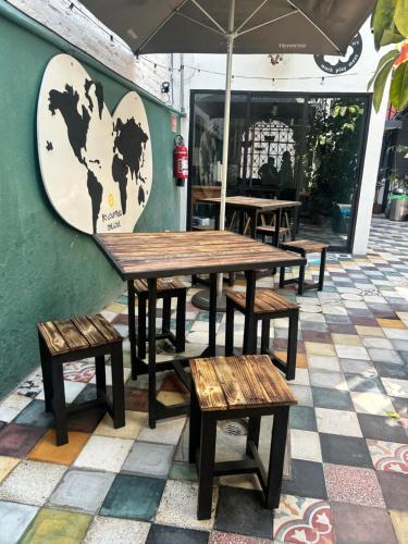 a group of wooden tables and benches against a wall at Casa Columpio in Mexico City