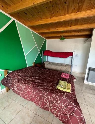 a bed in a room with a green wall at Depto Ruta 3 in Trelew