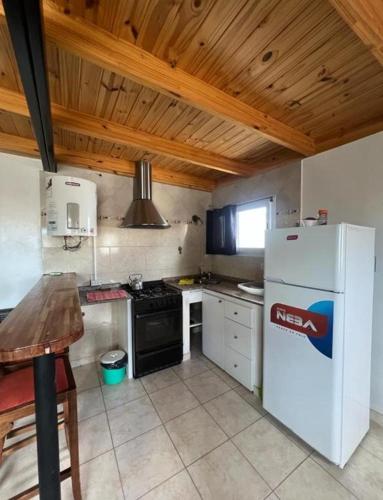 a kitchen with a white refrigerator and a stove at Depto Ruta 3 in Trelew