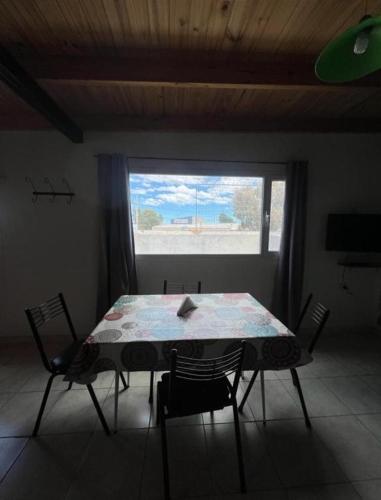 a table and chairs in a room with a window at Depto Ruta 3 in Trelew