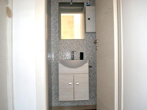 a bathroom with a white sink and a mirror at Wabis two-room apartment on the ground floor in San Foca in San Foca