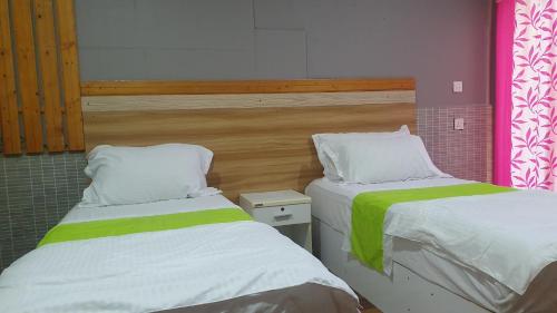 2 Betten nebeneinander in einem Zimmer in der Unterkunft Finimas Residence in Thimarafushi