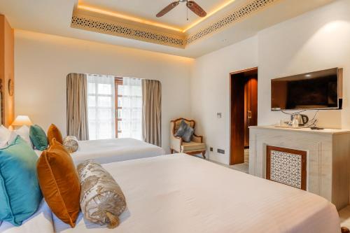 a hotel room with two beds and a fireplace at Juna Mahal Jungle Resort Ranthambore in Sawāi Mādhopur