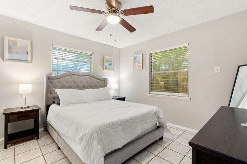 1 dormitorio con 1 cama y ventilador de techo en Cozy 3 bedroom with HOT TUB 2 min away from lackland en San Antonio