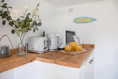 a kitchen counter with two glasses of orange juice at Little Highfield in Kingsbridge