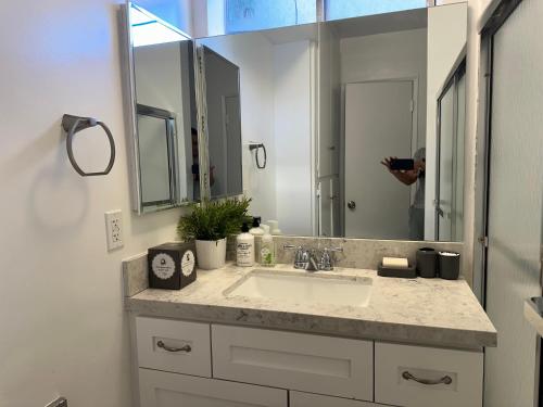 a person taking a picture of a bathroom sink at Exclusive Beverly Hills Apartment Awaits - Book now! in Los Angeles