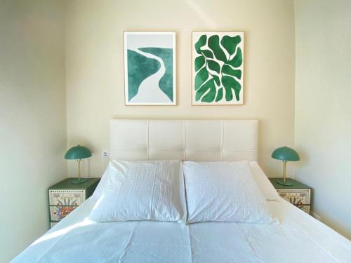 a bedroom with a white bed with two lamps at ESTUDIOS GRAN VÍA in Madrid