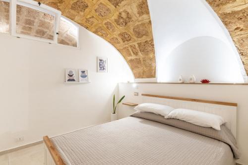 a bedroom with a bed in a white room at Sweet Hospitality - Apartments l Ferret24 in Alghero