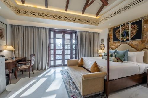 una camera con letto king-size e scrivania di Juna Mahal Jungle Resort Ranthambore a Sawai Madhopur