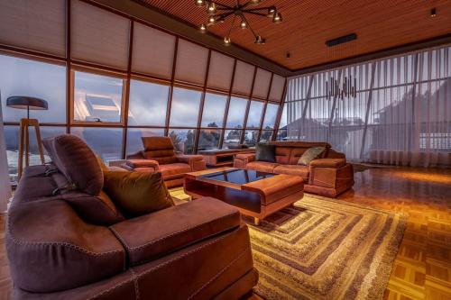 a living room with leather furniture and large windows at Luxurious Villa in Prevalla in Prevallë