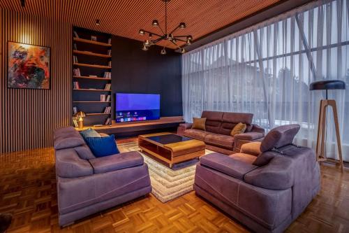 a living room with two couches and a flat screen tv at Luxurious Villa in Prevalla in Prevallë