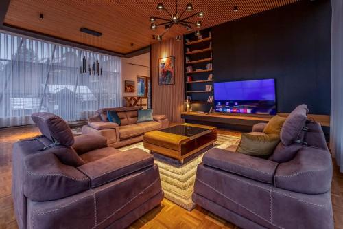 a living room with couches and a flat screen tv at Luxurious Villa in Prevalla in Prevallë