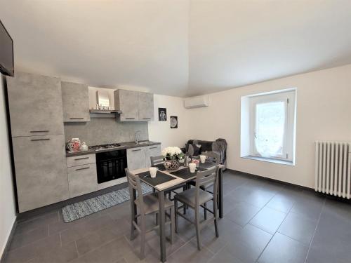 La casa di Ale في إندين جياناو: مطبخ مع طاولة وكراسي في الغرفة