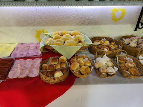a table with baskets of pastries and other foods at Pousada Atalaia in Campos do Jordão