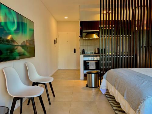 1 dormitorio con 2 sillas, 1 cama y cocina en STAY @ Palermo Hollywood (Soler), en Buenos Aires