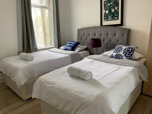 a bedroom with two beds and a couch at 2 Bed home-Sleeps 5-near station & great location in London