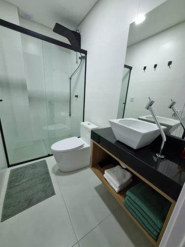 a white bathroom with a sink and a toilet at Flat Home Business 303 Centro de Pomerode in Pomerode