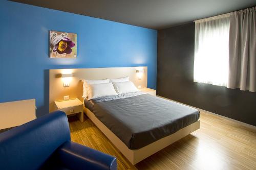 a blue bedroom with a bed and a blue wall at Residence Bleu in San Dorligo della Valle