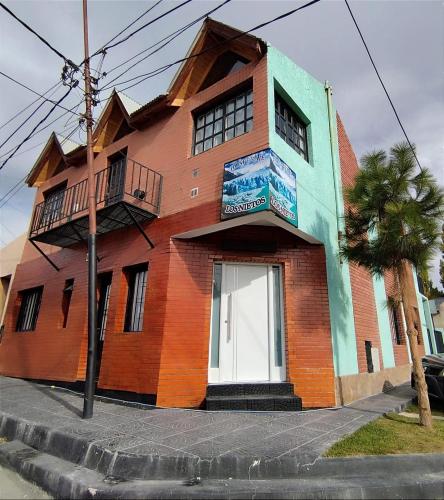 a brick building with a balcony on a street at Hospedaje Los Nietos in El Calafate