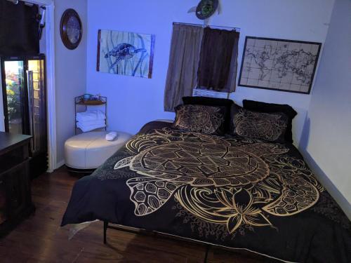 a bedroom with a bed with a gold and black bedspread at Turtle's Room in Las Vegas