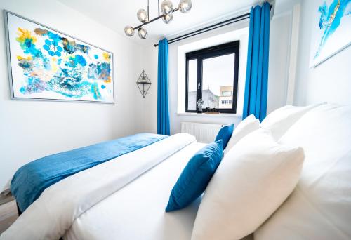 een slaapkamer met een bed met witte en blauwe kussens bij D&L Luxury Apartment in Old Town, Bratislava in Bratislava