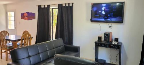 sala de estar con sofá y TV en la pared en casa la infancia en Perito Moreno