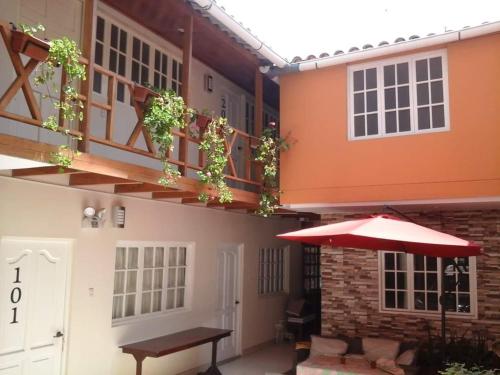 a patio with an umbrella and a table and a building at HOSPEDAJE VALERY in Trujillo