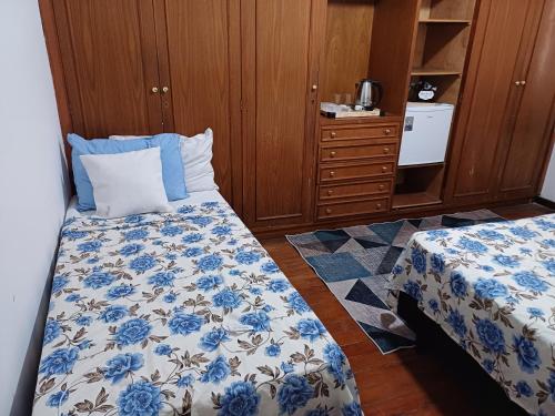 a bedroom with a bed and a dresser with a blue and white bedspread at #paradise suíte Tatuapé Executiva #4 in São Paulo