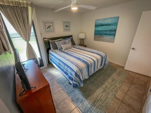 um quarto com uma cama e uma televisão em Maui Vista Vacation Condo em Kihei