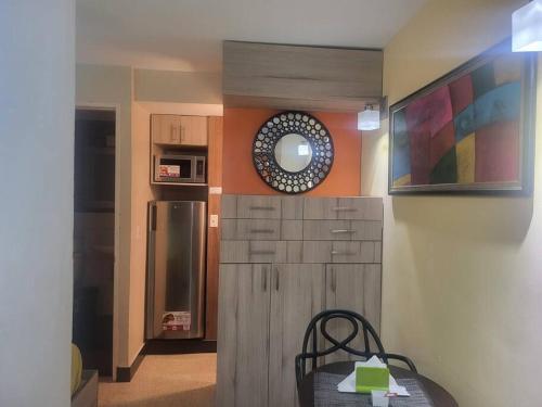 a kitchen with a refrigerator and a table with a mirror at R.503 Lindo y funcional apartaestudio en el centro in Panama City