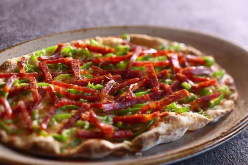 a pizza sitting on a plate on a table at HOTEL THE MITSUI KYOTO, a Luxury Collection Hotel & Spa in Kyoto