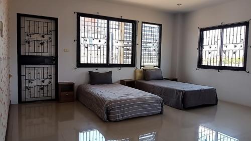 a bedroom with two beds and a couch and windows at U Zone Hostel & Cafe in Surat Thani
