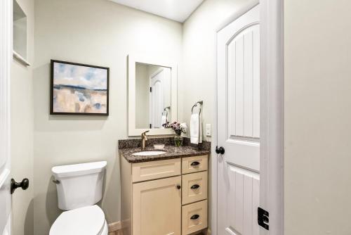 a white bathroom with a toilet and a sink at Private Heated Pool - 100 Steps to Beach Access - 5-min walk to Siesta Key Village in Siesta Key