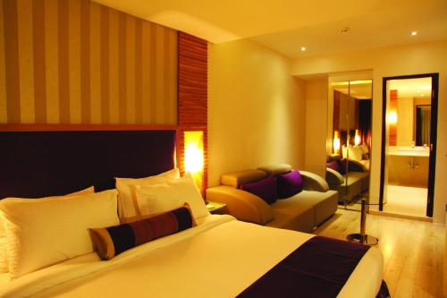 um quarto de hotel com uma cama e uma sala de estar em The Purple Leaf Hotels em Hyderabad