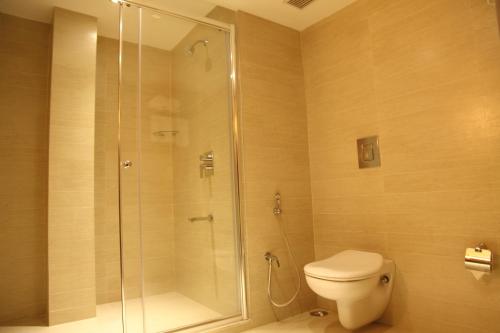 a bathroom with a shower and a toilet at The Purple Leaf Hotels in Hyderabad