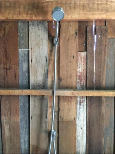 eine Dusche in einem Zimmer mit einer Holzwand in der Unterkunft สวนบ้านนอก SuanBaanNoak in Phayao