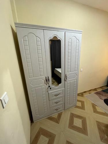 a cabinet with a mirror in the corner of a room at Apartment luxe Atilamonou in Lomé