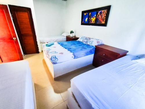 ein Schlafzimmer mit 2 Betten und einer Kommode darin in der Unterkunft Hotel Palmahia Moñitos in Moñitos