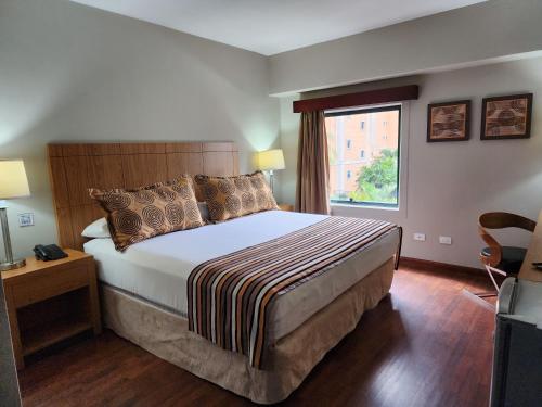 a bedroom with a large bed and a window at Hotel GH Guaparo INN in Naguanagua