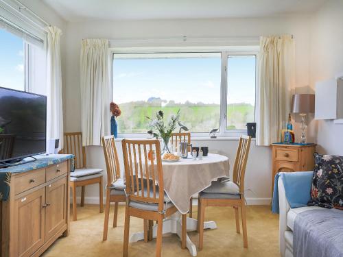 sala de estar con mesa, sillas y ventana en Sea Breeze en Wembury