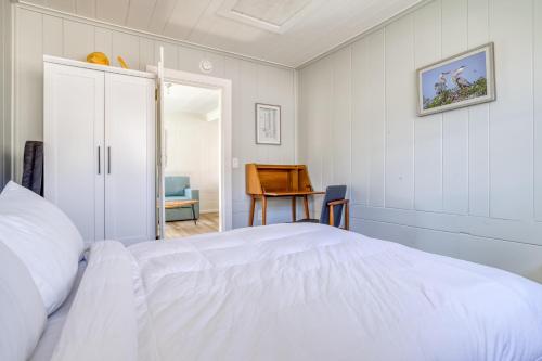 a white bedroom with a bed and a table at Odyssey in Cannon Beach