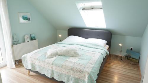 een slaapkamer met een bed met een deken en een raam bij Fewo Aron in Tönning