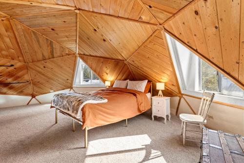 Cama en habitación con techo de madera en Dome Home, en La Pine