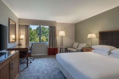 ピーターバラにあるDelta Hotels by Marriott Peterboroughの大きなベッドと机があるホテルの部屋