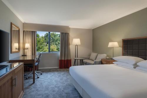 ピーターバラにあるDelta Hotels by Marriott Peterboroughの大きなベッドとデスクが備わるホテルルームです。