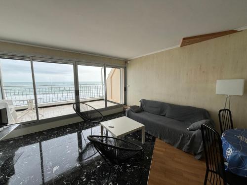 un salon avec un canapé et une vue sur l'océan dans l'établissement Appartement 3 pièces face plage avec terrasse et garage - Les Sables d'Olonne - FR-1-197-388, à Les Sables-dʼOlonne