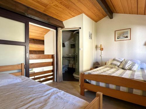 sypialnia z łóżkiem i drzwiami do łazienki w obiekcie Maison en Pinède Proche Mer et Commerces - 5 pers, Terrasse, Jardin, Parking, WiFi - FR-1-705-29 w mieście La Palmyre